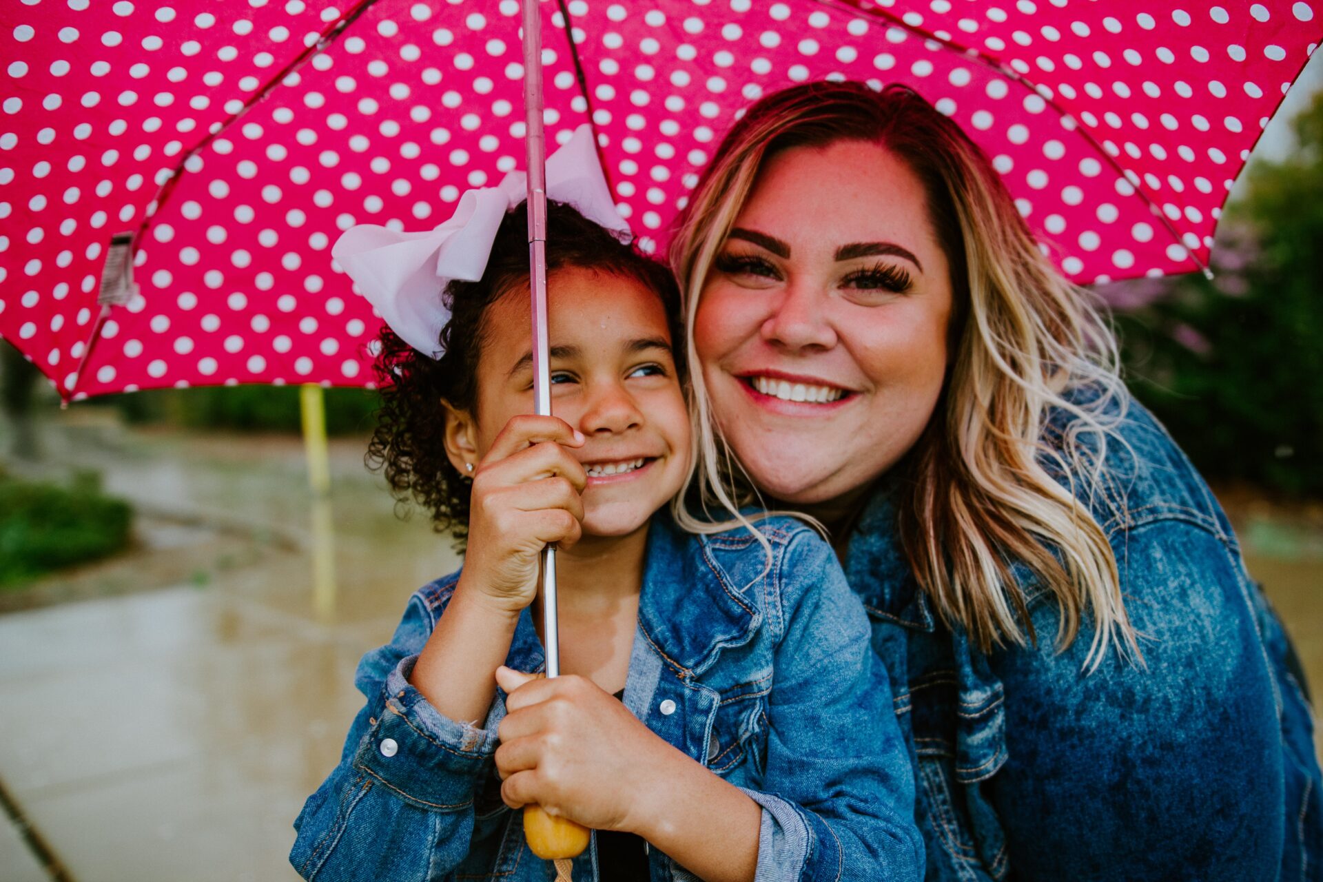 Mom with little girl under an umbrella.